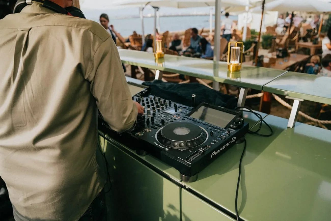 A DJ setup on the outdoor kitchen counter with guests gathered behind