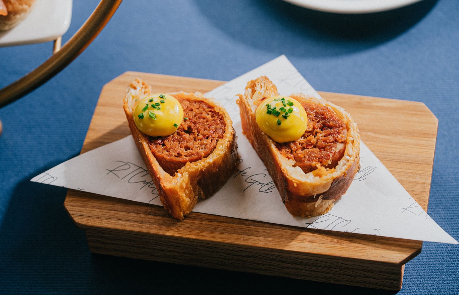 Croque monsieur on a wooden board, on RT Café Grill paper