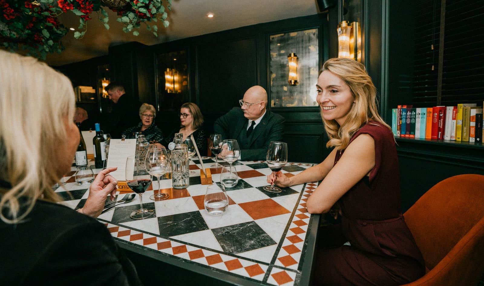 Guests at the long table in The Cellar, beside the glass-fronted wine cellar