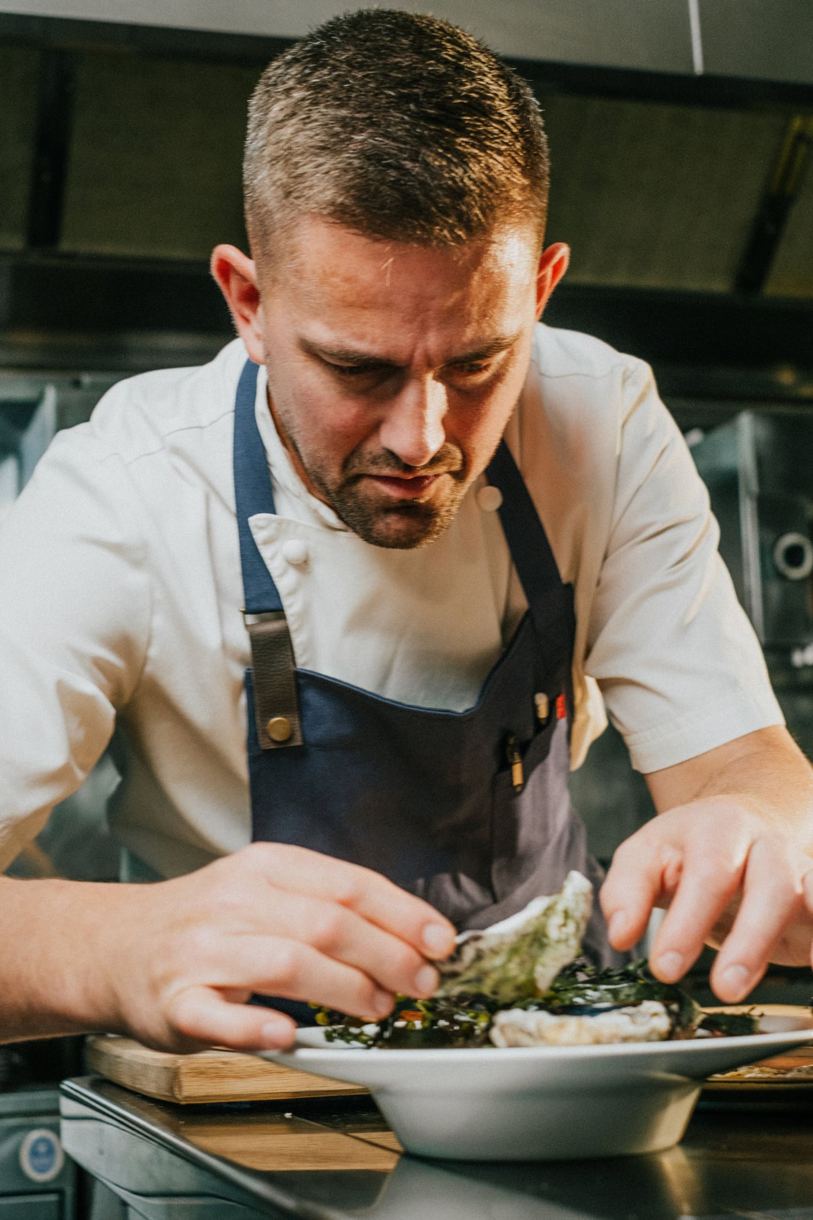Robert dressing oysters on a white plate