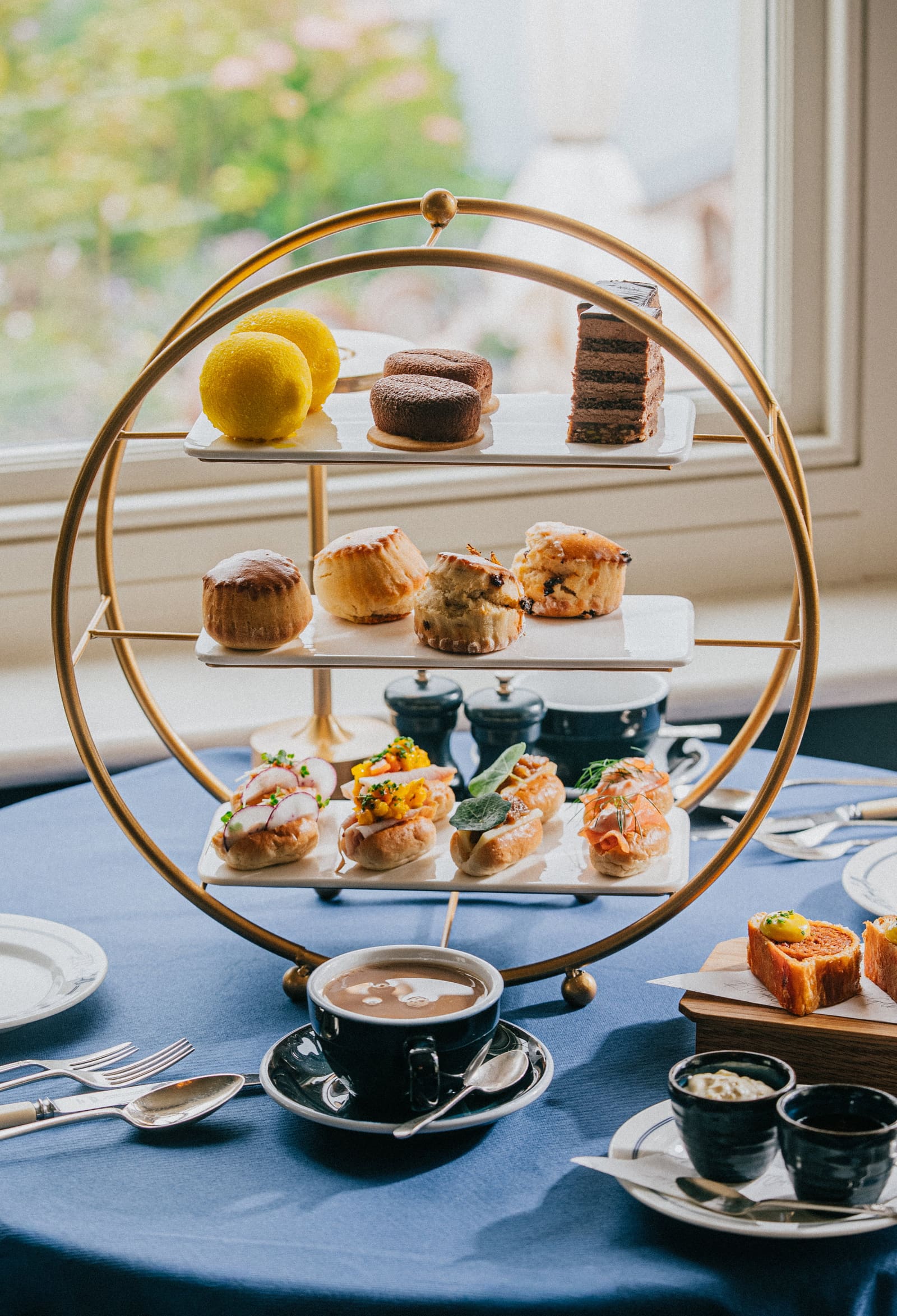 Afternoon tea on the brass stand by the window, the garden behind