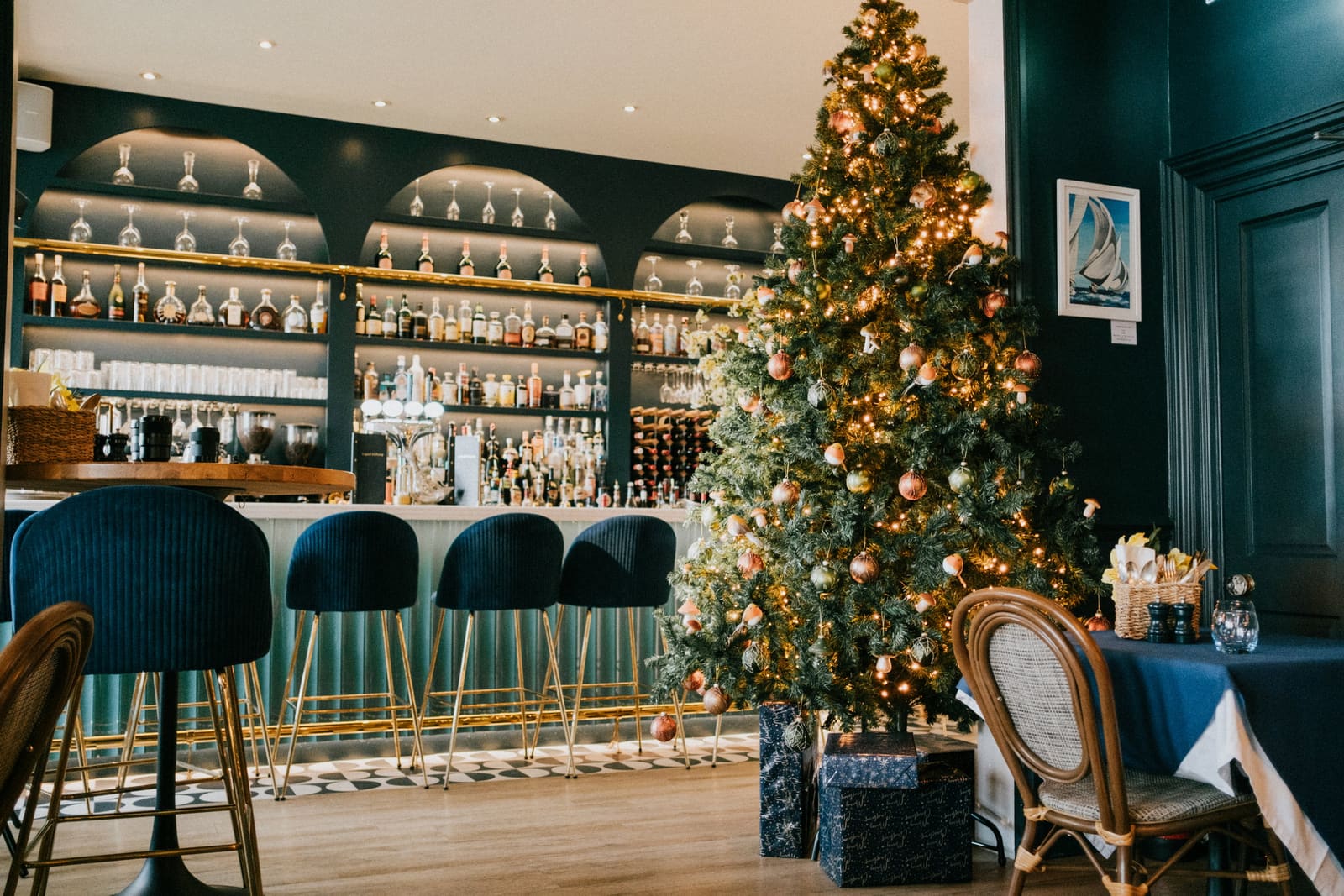 The bar at RT Café Grill dressed for Christmas: a lit tree beside the bottles, presents underneath